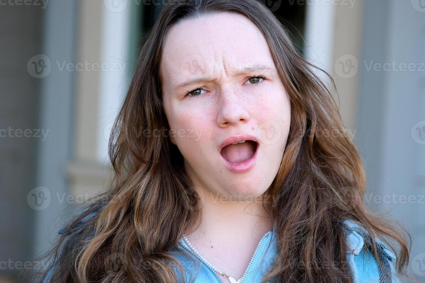 Young disappointed and unhappy beautiful woman in casual clothes crying. Woman model makes dissatisfied and angry expression front of the windows shutter. Copy space photo