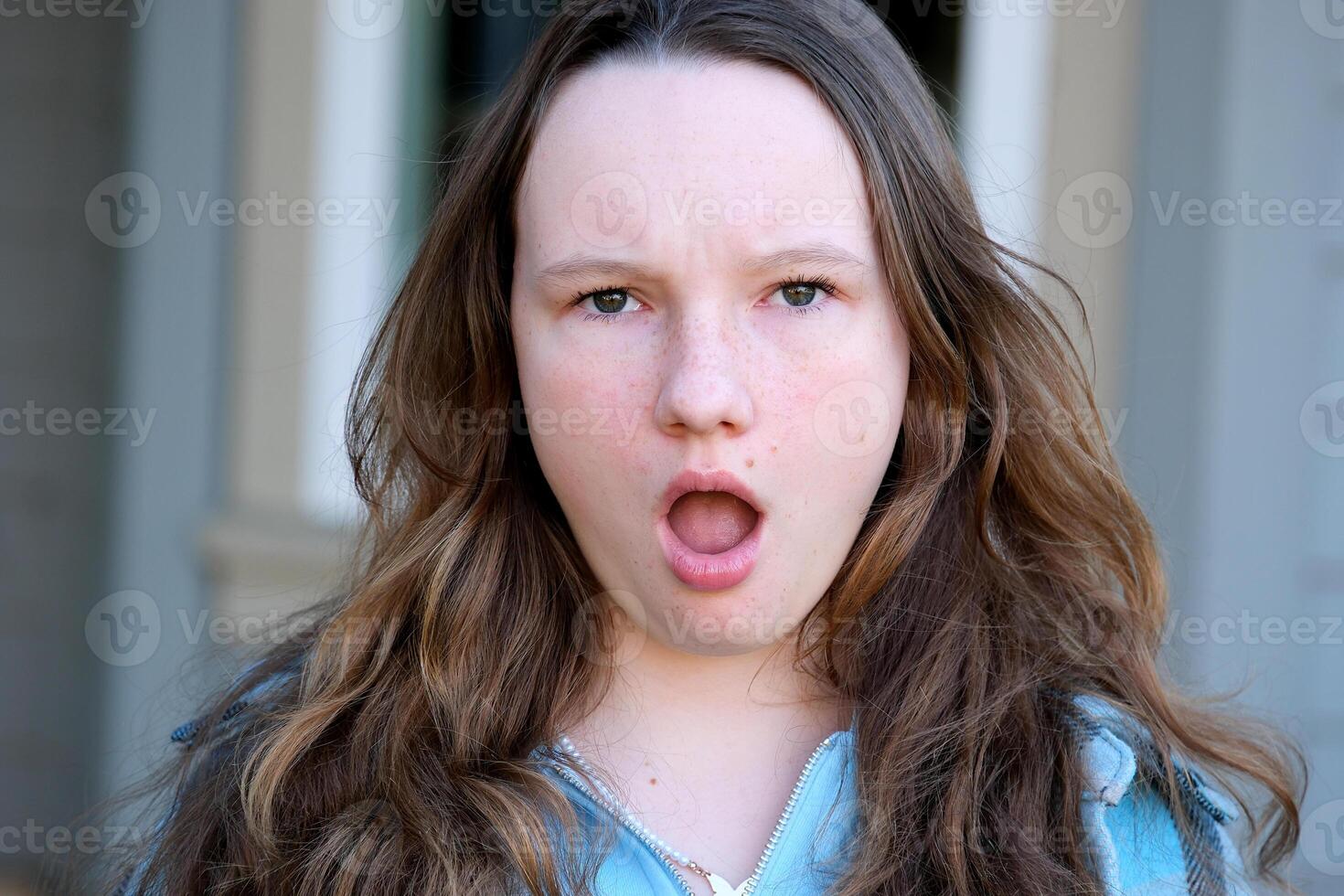 How could you Portrait of disappointed unhappy teenager girlt standing with raised hands asking what do you want, angry face. Indoor studio shot isolated on gray background. photo