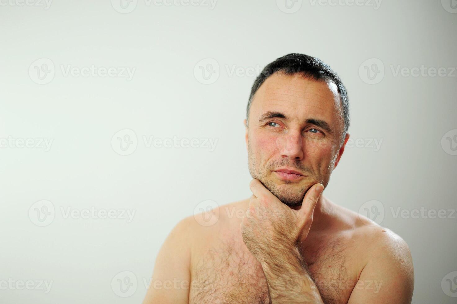 a brooding man with a bare torso Right side Here is a place for text Bare torso hairy chest Thoughts Beautiful sparkling blue eyes photo