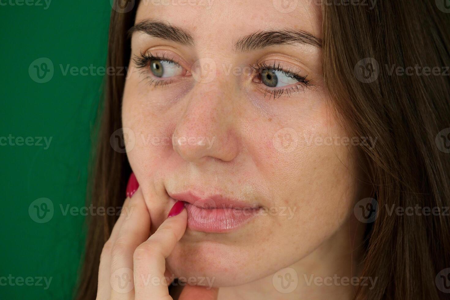 Face expression suffering from sensitive teeth and cold, asian young woman, girl feeling hurt, pain touching cheek, mouth with hand. Toothache molar tooth, dental problem isolated on green background. photo