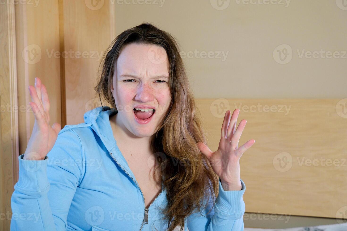 Redhead woman wearing easter rabbit ears at home annoyed and frustrated shouting with anger, crazy and yelling with raised hand, anger concept photo