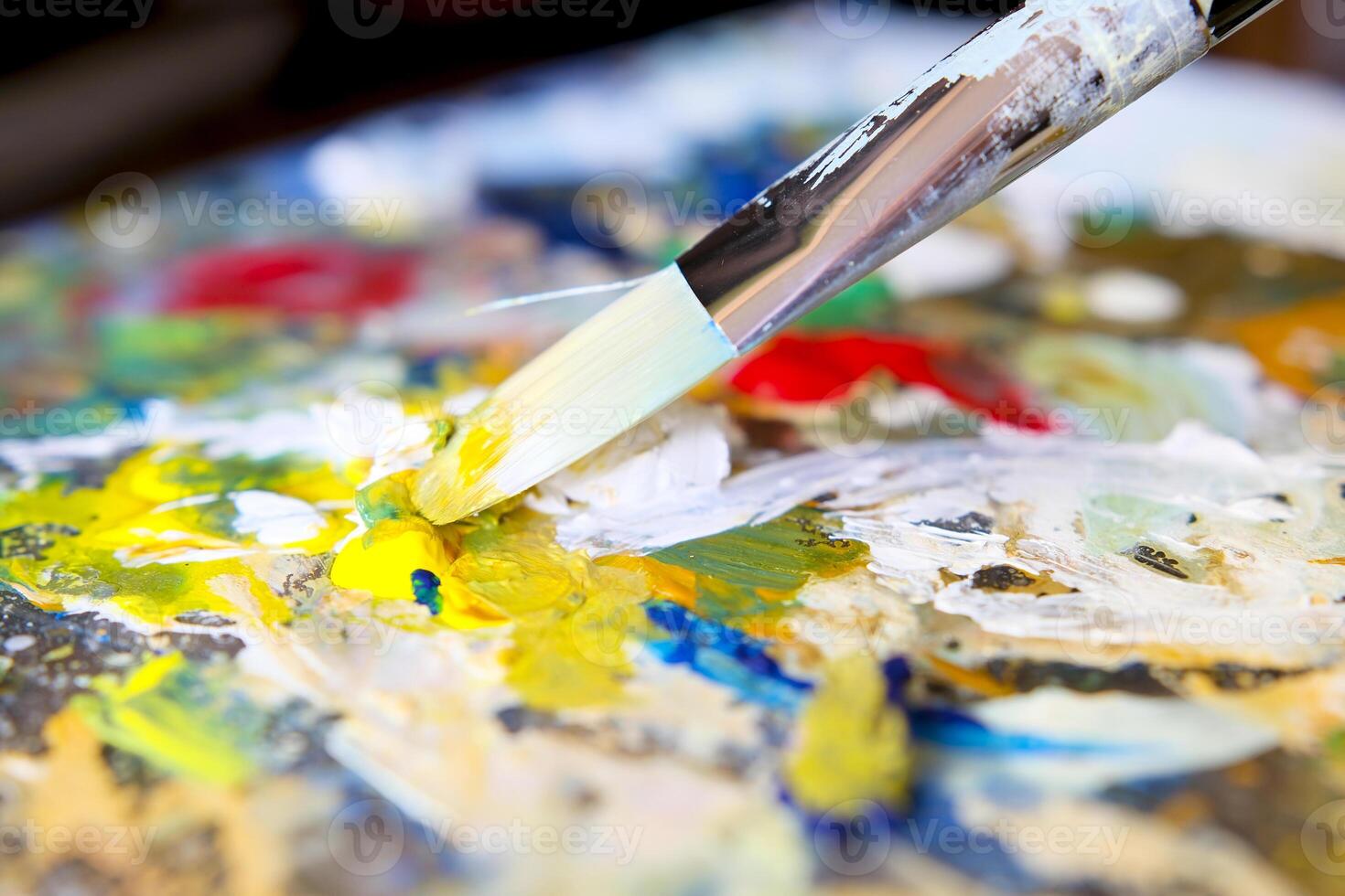 Artist's brushes and old palette with oil paints, drawing and creativity. Toned photo