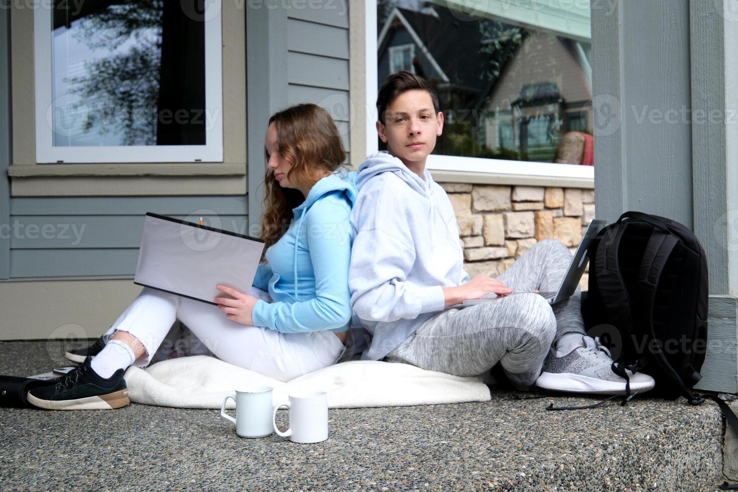 pleasant relationship teenagers boy and girl doing lessons together on laptop laughing talking sitting outside pleasant cute kids people show joy tenderness communication briefcase canada america photo