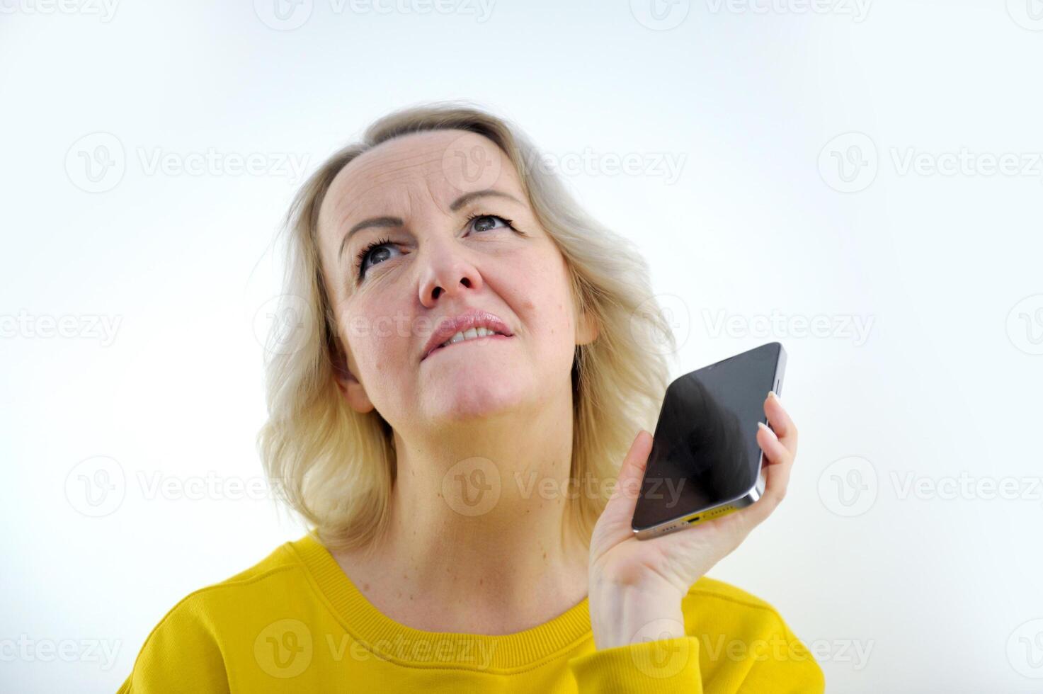 dreams waiting thinking planning woman holding the phone raised her eyes up biting her lip thinks what to do next Whom to call how to solve the problem beautiful neck photo