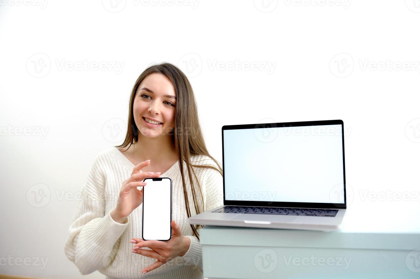a nurse with a phone in her hands is typing a text message in the foreground a laptop with a white chroma key screen empty space for text photo