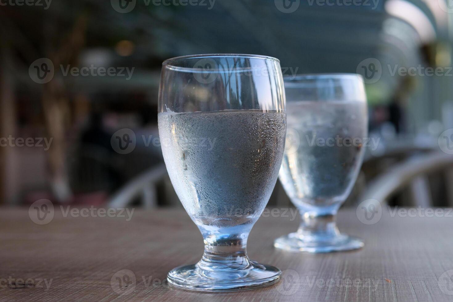 two glasses of water on table misted glass cold drink pure water diet health wooden table blurred background on empty stomach drinking clean water spring water serving in restaurant at beginning photo