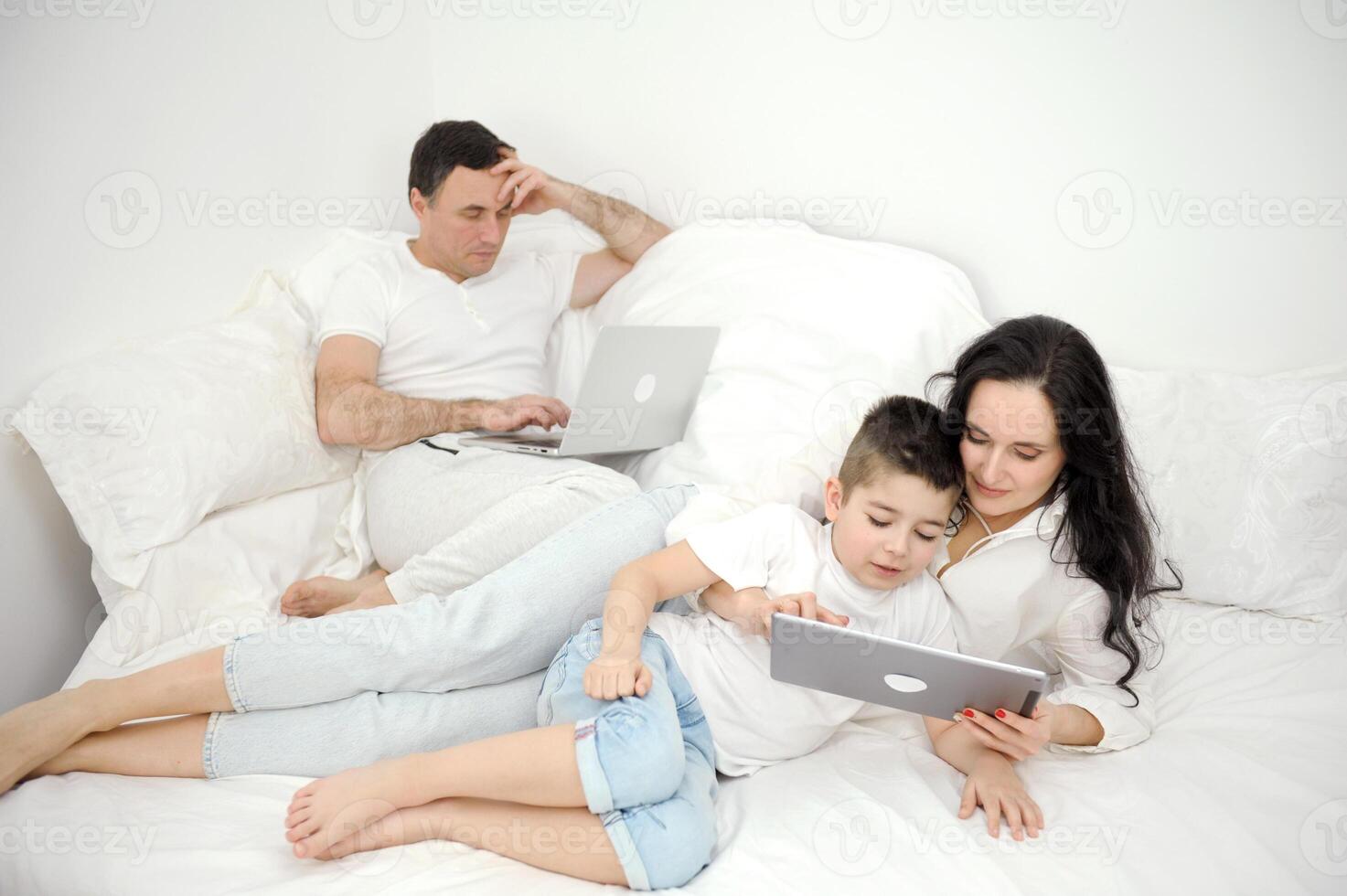 mom entertains son on tablet white clothes one bed rest apartments idyll spend time together be alone with yourself family modern communication online internet social networking computer communication photo