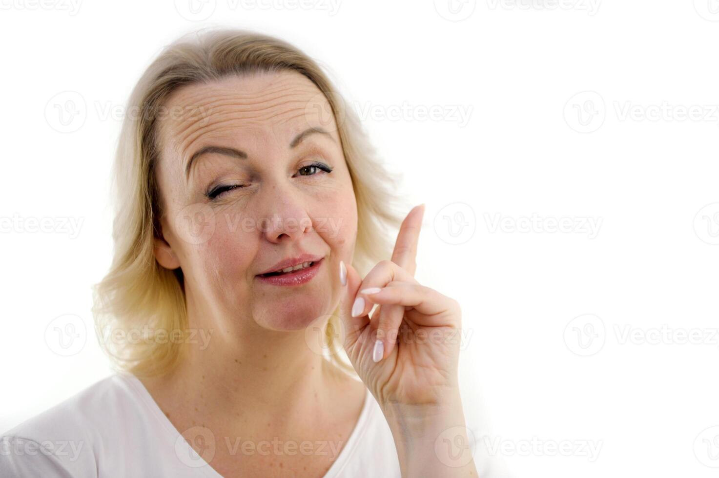 Attention listen to me. Close up portrait woman wagging her finger holding glasses skeptically isolated white grey wall background. Negative human emotion face expression body language attitude photo