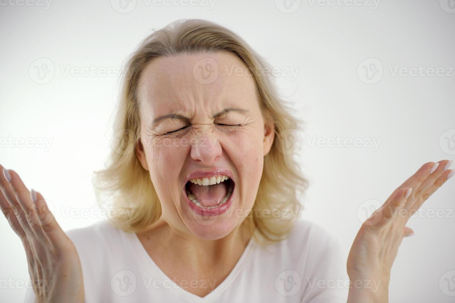 screaming loudly dissatisfied woman sad angry spread her arms to sides spread fingers pinched eyes screaming hysteria nerves psychological help nervousness antidepressants studio on white background photo