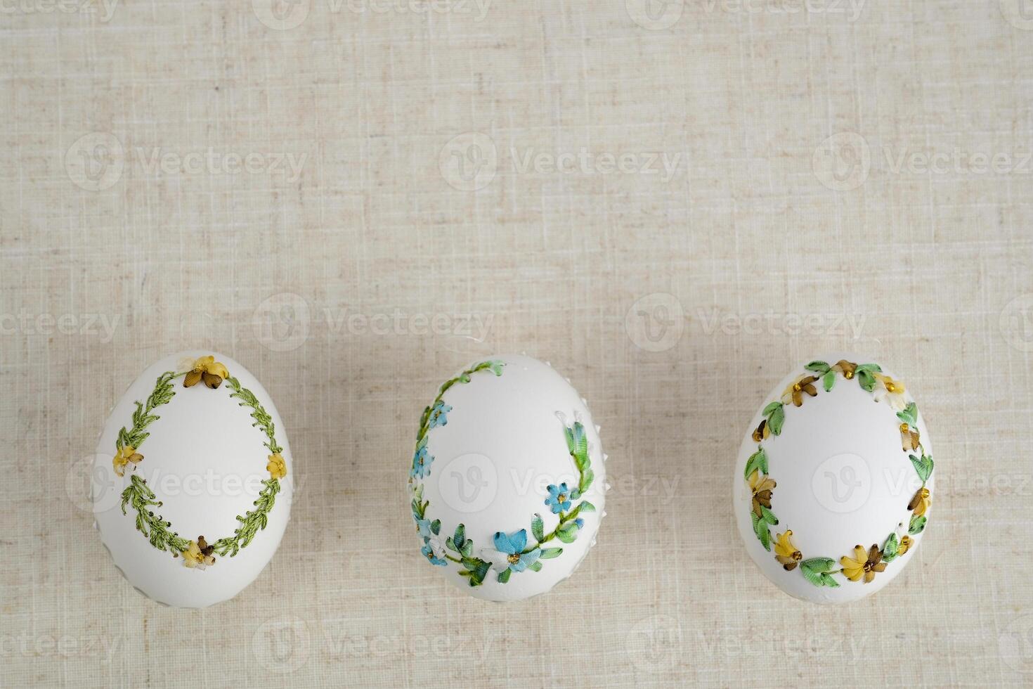 Composition with Easter eggs on a beige background embroidery on an eggshell Easter holiday background for text billboard banner postcard calendar background for text photo