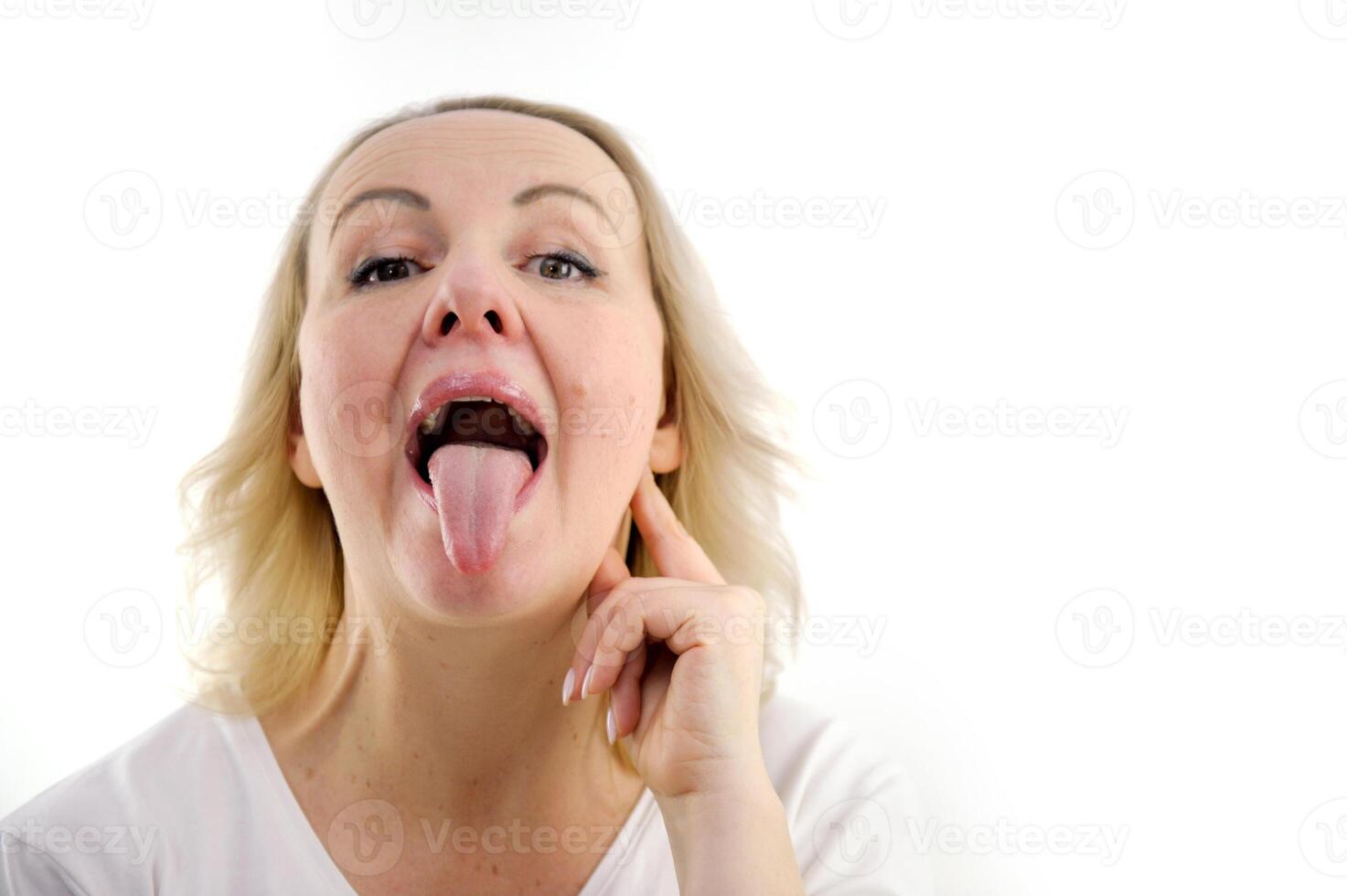Young brunette woman wearing business jacket sticking tongue out happy with funny expression. emotion concept. photo