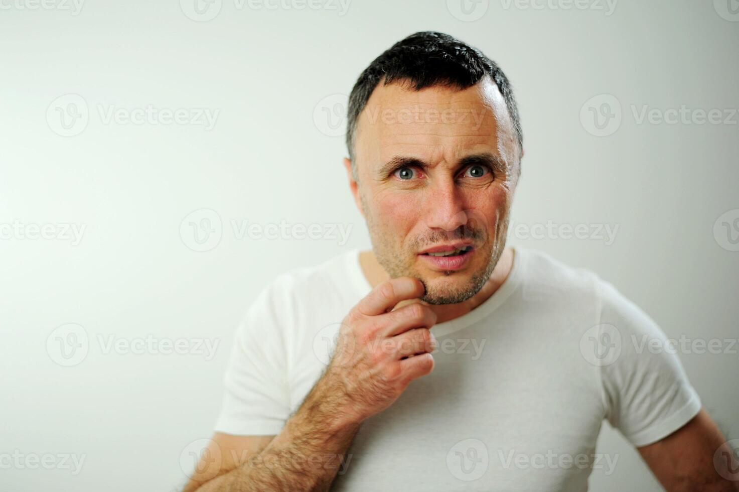 bewilderment angry unshaven man looks into the frame Point your finger directly at the camera Are you serious dissatisfaction disappointment Negative emotions white studio I will find you photo