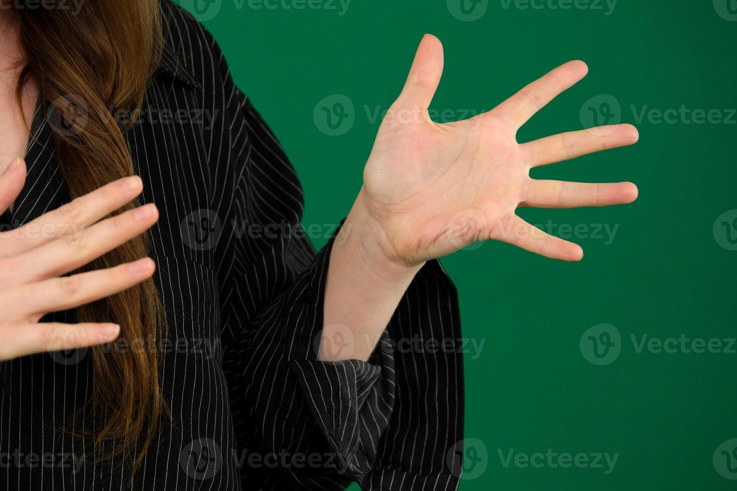 Young girl emotionally shouts expression of emotions with hands unrecognizable people hands palms fingers close-up on a green background chromakey feelings photo