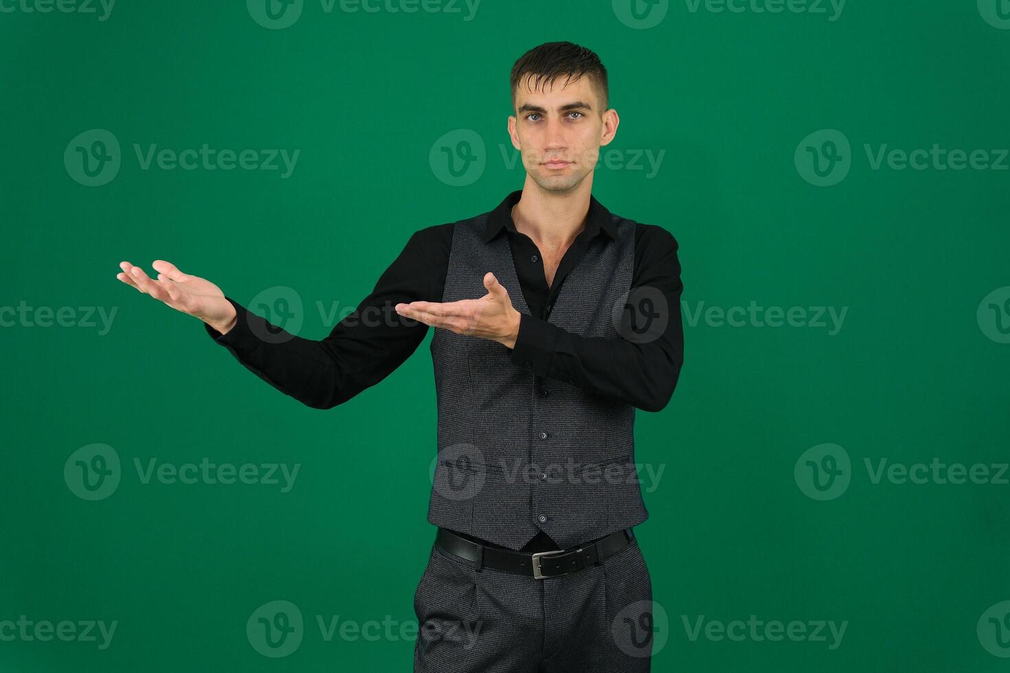 business man pointing at something as if he was presenting emotions of a handsome man guy on a green background chromakey close-up dark hair young man photo