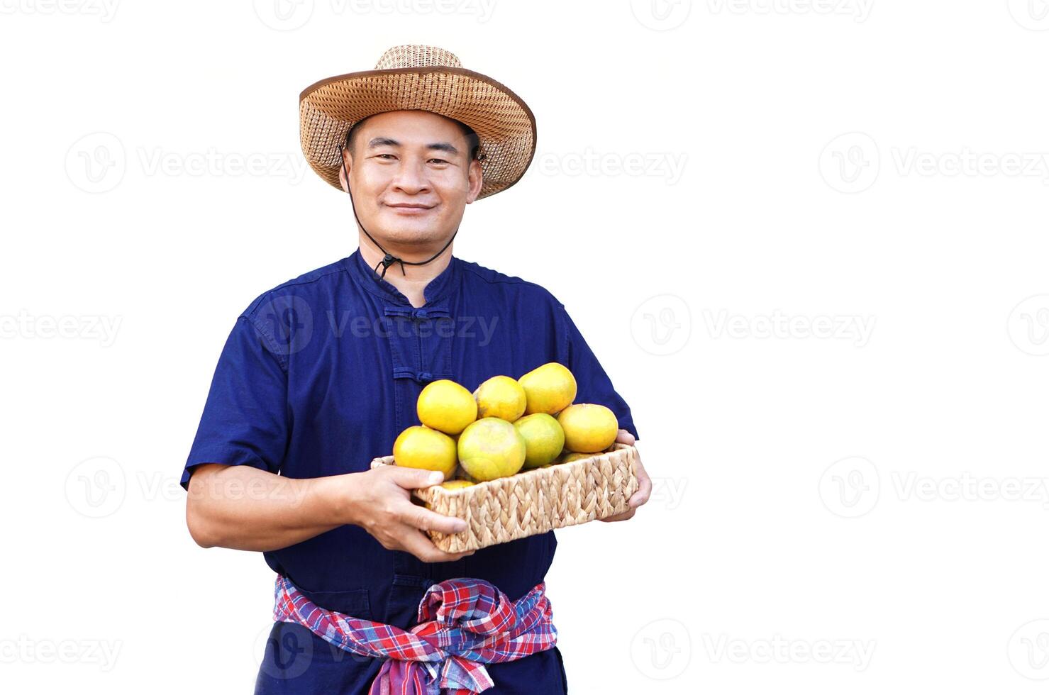 Handsome Asian man farmer wears hat, blue shirt, holds basket of organic orange fruits, isolated on white background. Concept, Agriculture occupation, produce crops to market. photo