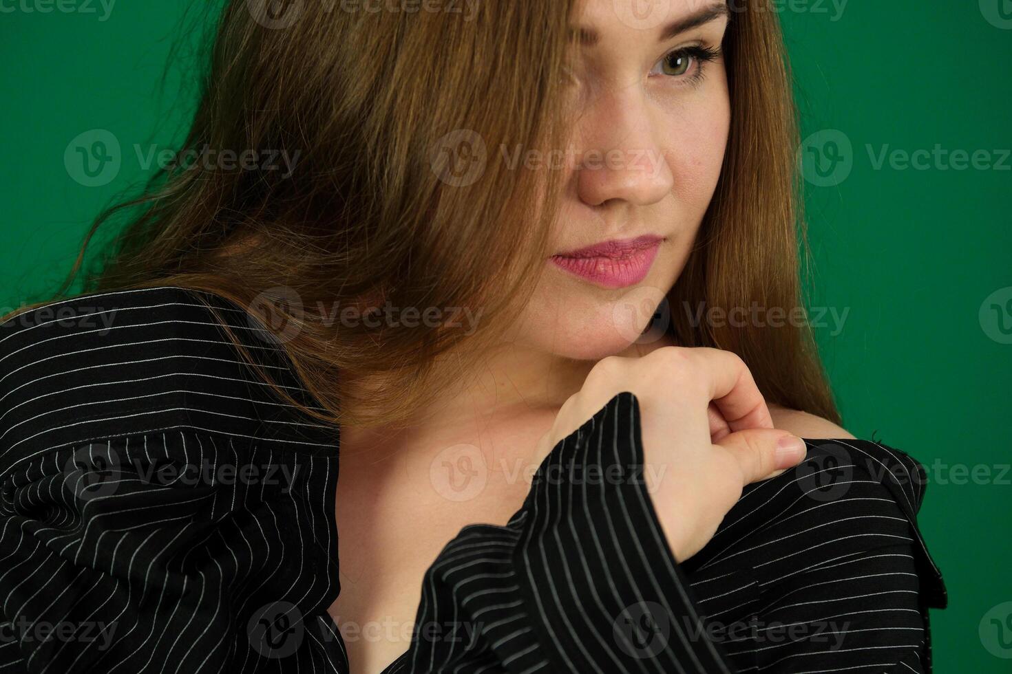 Concept close-up portrait of pretty girl, a young woman with long beautiful brown hair and a black jacket on a white background. In the studio in different poses showing emotions. photo