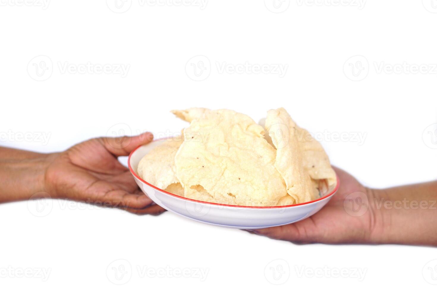 Close up hands holds plate of crisp rice cakes, traditional food. on white background. Concept, giving , serving and sharing food. Traditional Thai snack, made from dried dough and deep fry. photo