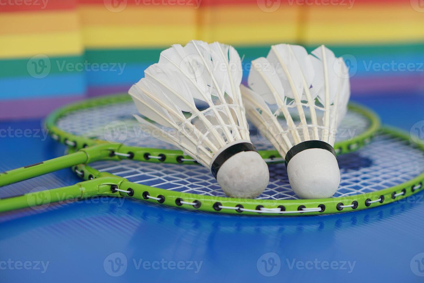 Badminton shuttlecocks on racket. Blurred rainbow colors background. Concept, sport, exercise, recreation activity for good health. Popular sport for all genders and LGBTQ worldwide. photo