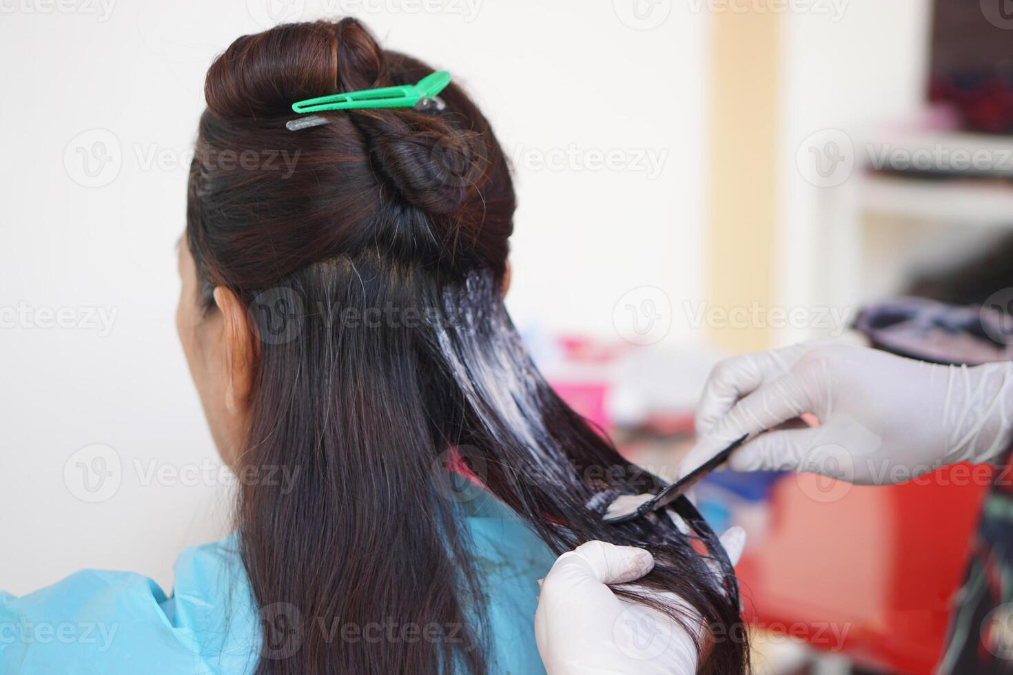 Close up hairdresser hands wears gloves, apply dye color cream on client's hair. Concept. Woman shouldn't stop beauty. Hair health care. Change hair color, cover gray hair with dye color. Hairstylist photo