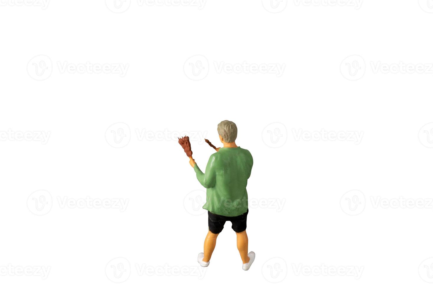 Miniature people , A young man with a BBQ Isolated on white background with clipping path photo