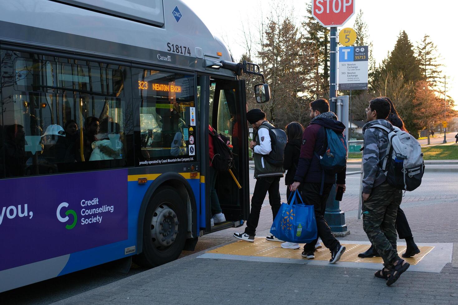 Vancouver, Canada 2023 People lining up to board a Translink bus on West Georgia Street in Downtown Vancouver photo
