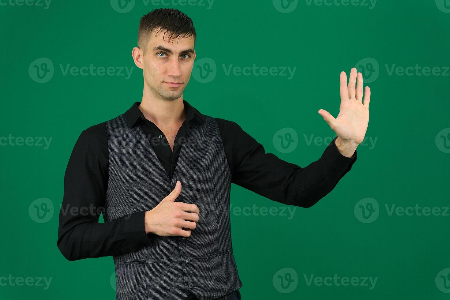 spy emotions of a handsome man guy on a green background chromakey close-up dark hair young man photo
