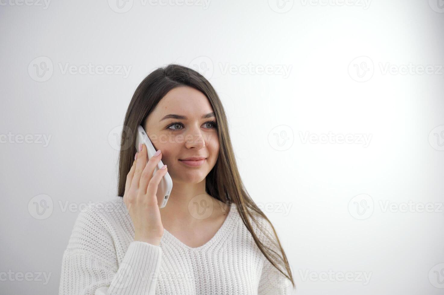 Frustrated brunette hispanic young woman talking by phone with husband, in troubles. Pretty caucasian girl at home using cell phone looking hopelessly at window. Upset housewife. Mockup sad girl. photo