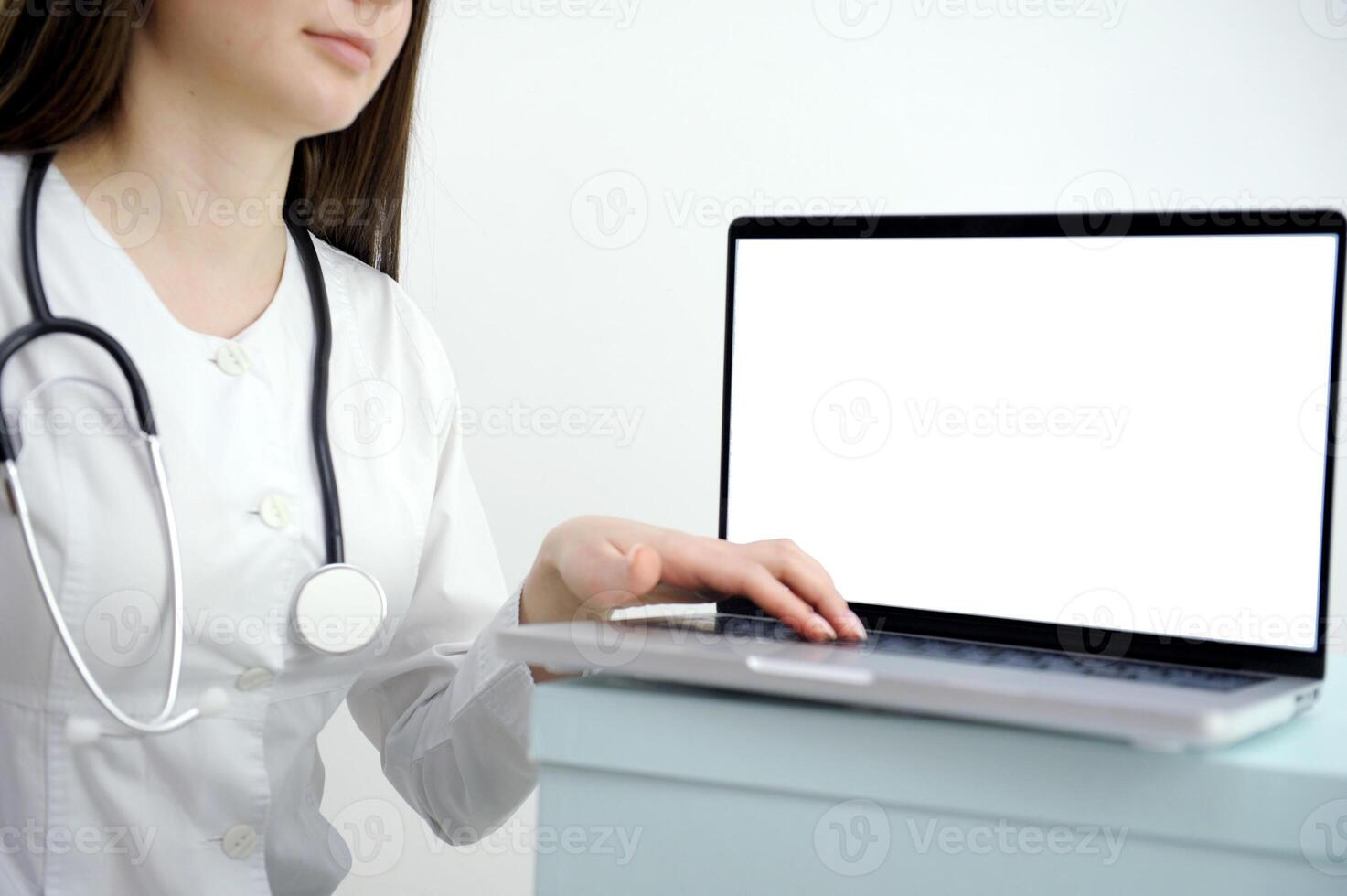 Medical worker a woman in a white coat uses a tablet in the office at the Desk, chromakey on the tablet screen, a view over her shoulder photo
