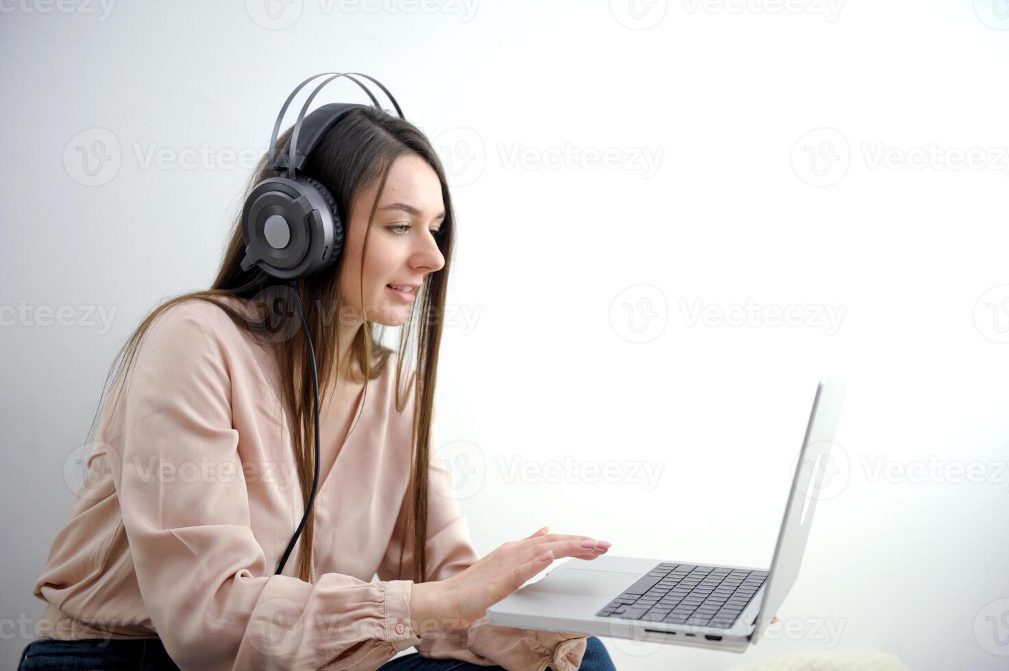 Attractive and happy young female student studying online, sitting at desk, using laptop computer, having chat, waving, education concept. photo