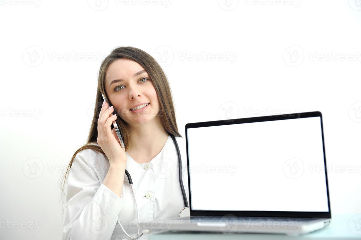 Medical worker a woman in a white coat uses a tablet in the office at the Desk, chromakey on the tablet screen, a view over her shoulder photo