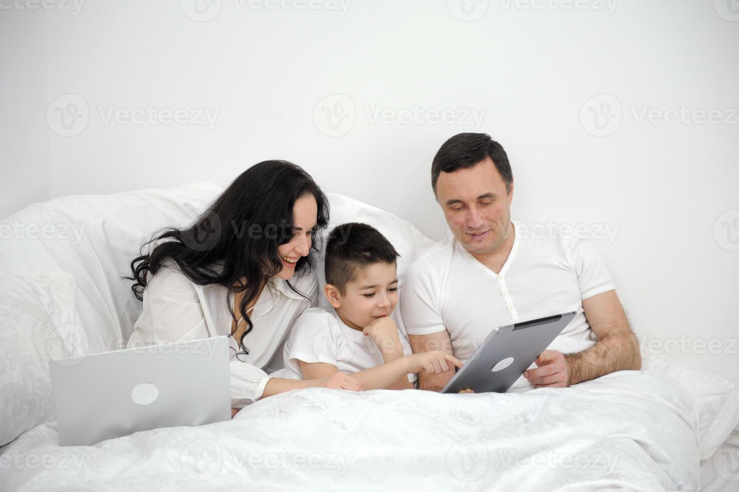 dad Mother and son under the blanket with a digital tablet. kid dream online night games at concept. family watching online under covers with digital tablet. social media photo