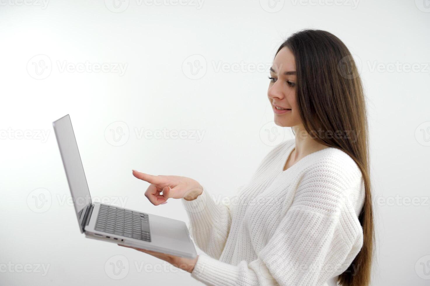 beautiful girl laptop in her hands points finger at the screen long hair advertising interesting content business, office, school and education concept smiling businesswoman with touchscreen in office photo