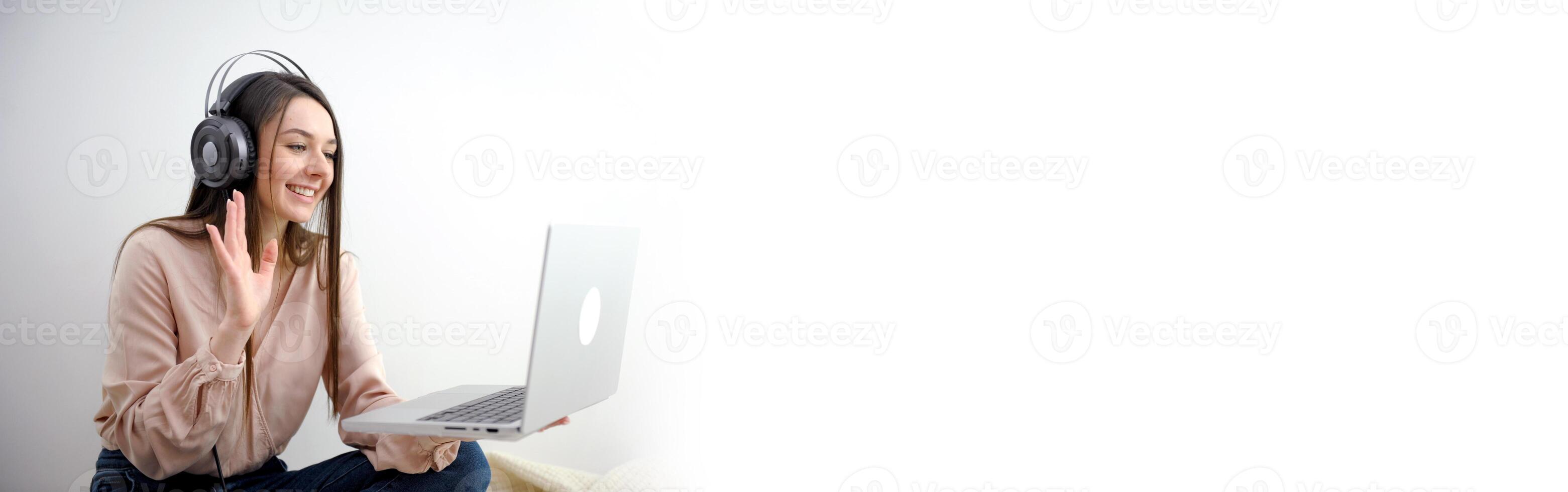 banner girl with laptop in headphones communicates online conference with friends waving a lot of space for text ad gadgets online courses internet social networks Web studio woman beautiful teeth photo