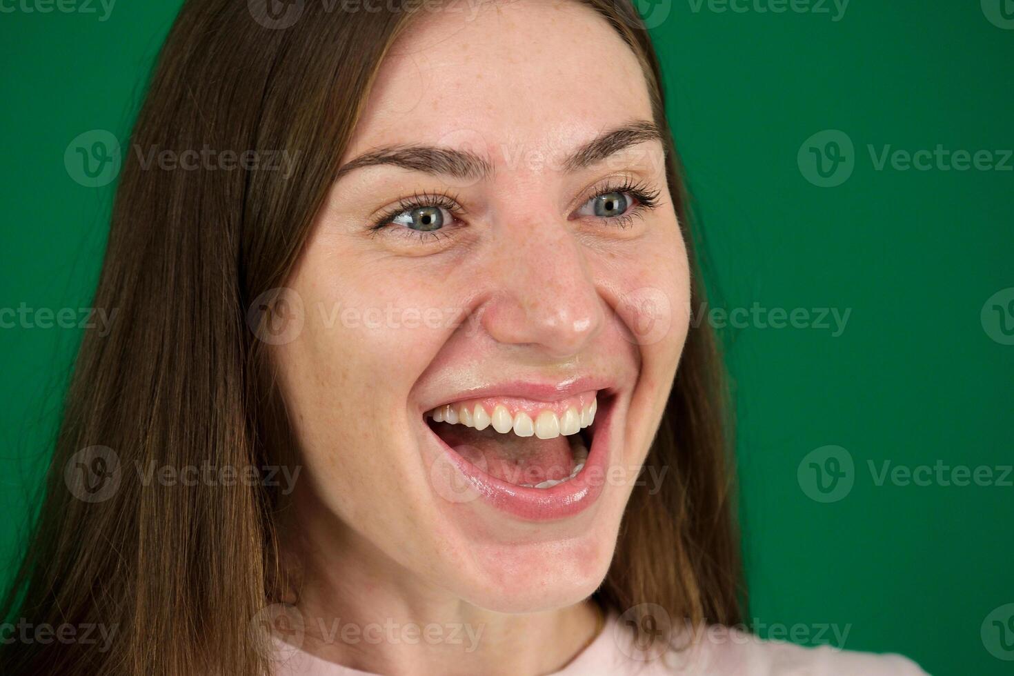 Center-front portrait of a joyous woman, who's laughing and smiling. She's wearing a formal white shirt, long hair, good teeth, emanating positivity and good news vibes photo
