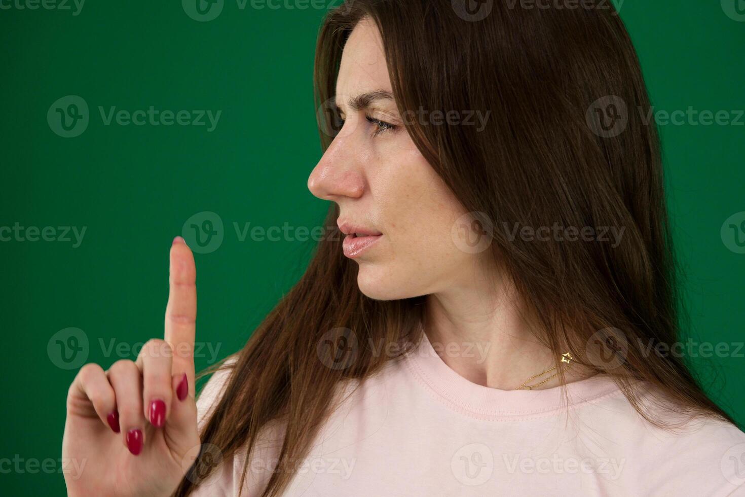 beautiful woman showing expressions. different emotions of a young girl on a green background chromakey beautiful facial features real people pink T-shirt white skinned. European photo