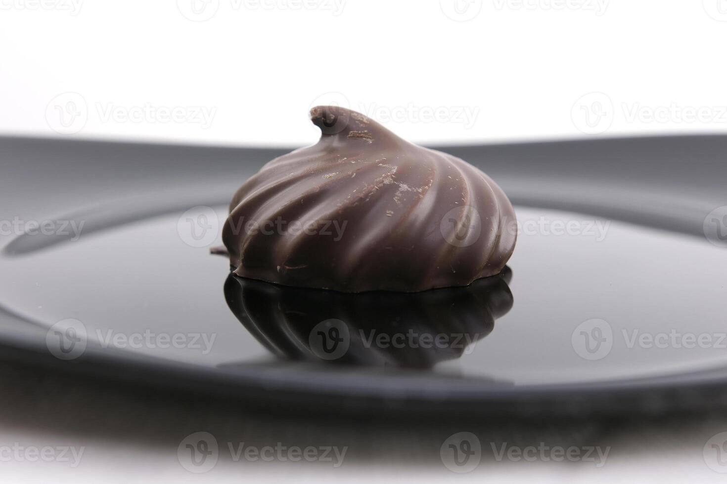 Melted chocolate is poured on a chocolate sweet and delicious chocolate covered marshmallow on a wooden table. 4K. photo