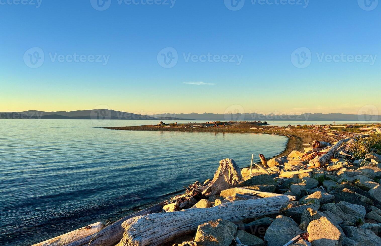 sunset on the Ocean Calmness calm sea on Vancouver Island resting in trailers on the shore bright colors of dark blue orange stripe on the horizon from the sun rich space for text travel advertising photo