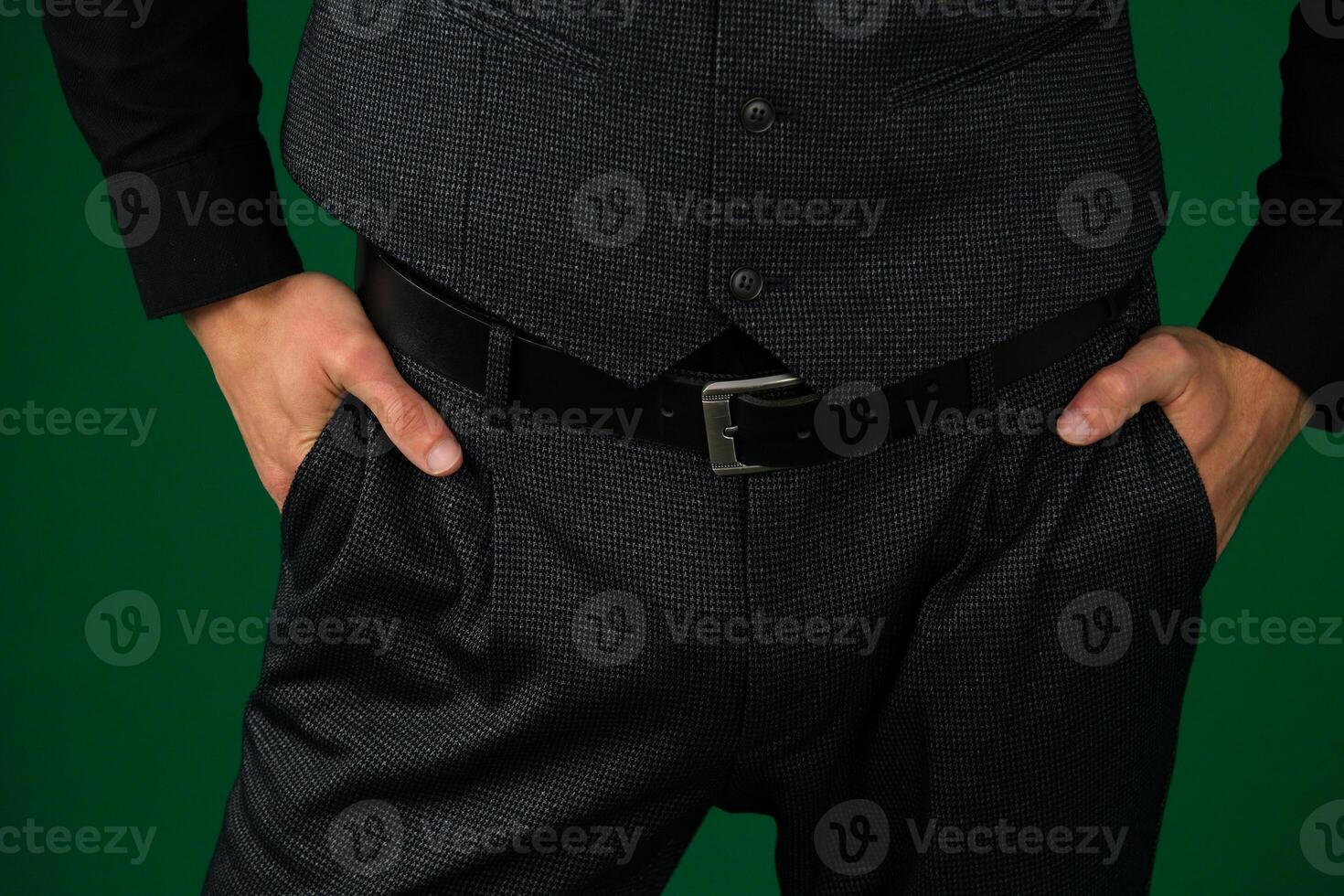 A man's hand in the pocket of gray stylish trousers close-up on a white background. Successful young man, businessman, entrepreneur in an expensive business brown suit, vest photo