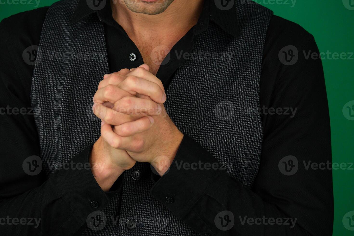Hands on knees with crossed fingers of a man photo
