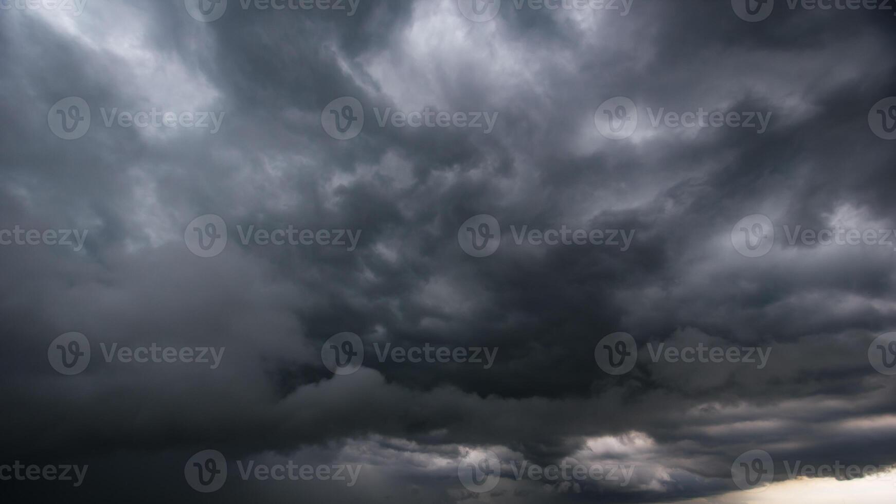 The dark sky with heavy clouds converging and a violent storm before the rain.Bad or moody weather sky and environment. carbon dioxide emissions, greenhouse effect, global warming, climate change. photo