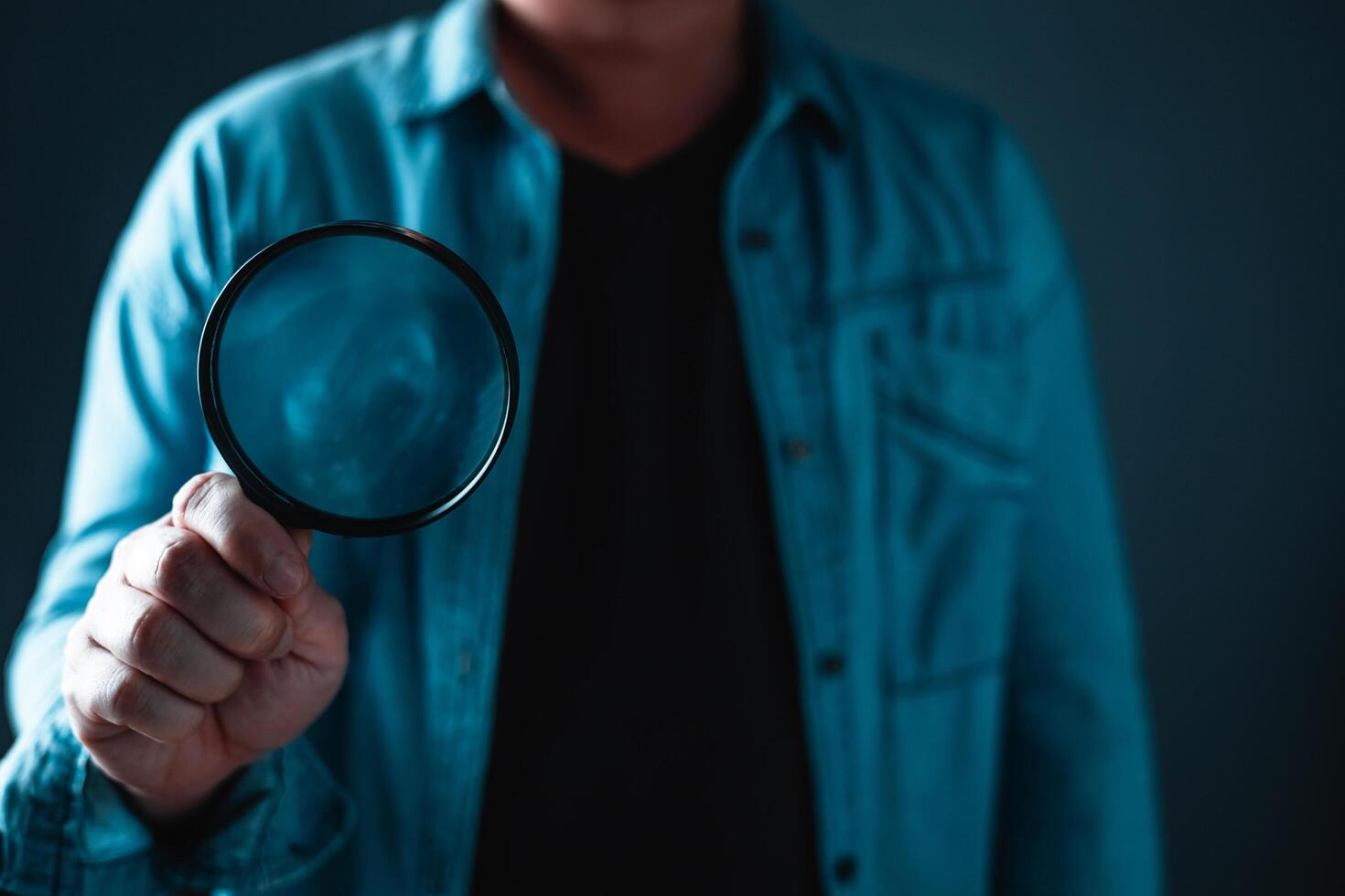 Businessman standing and holding magnifying glass Searching for information. Finding and research concept. photo