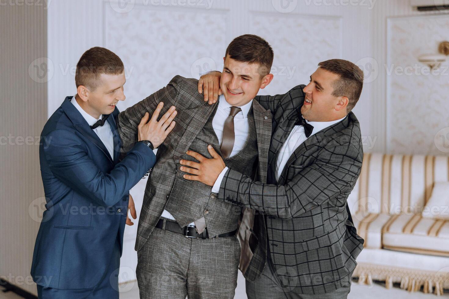 Three men in suits are hugging each other photo