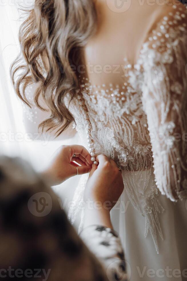 A woman is getting ready for a wedding and is adjusting her dress photo
