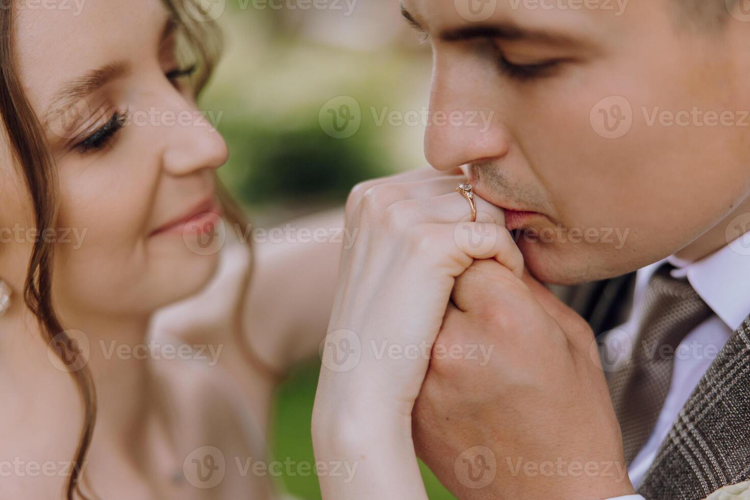 A man and woman are holding hands and the man is wearing a wedding ring photo