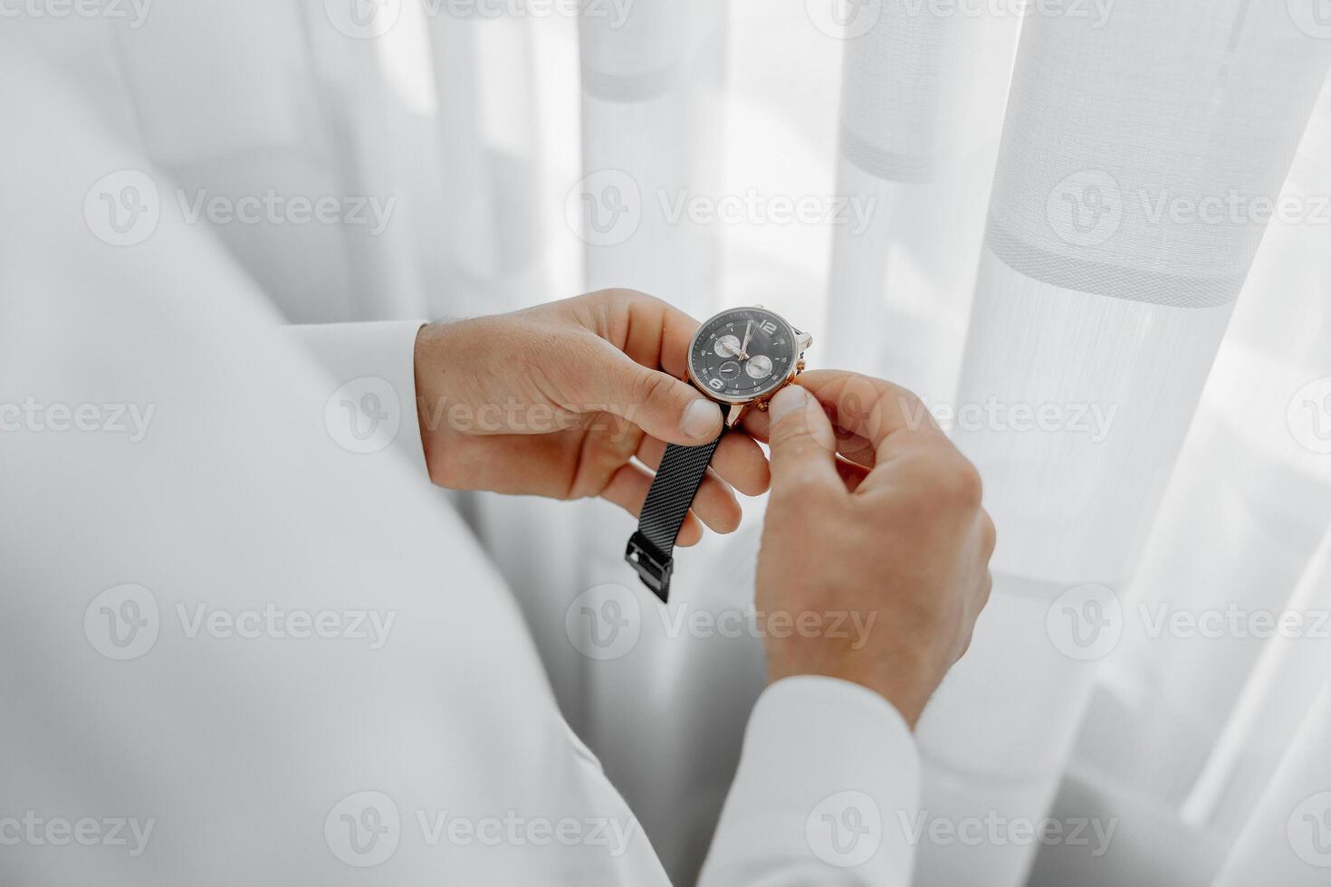 A man is wearing a watch and adjusting it photo