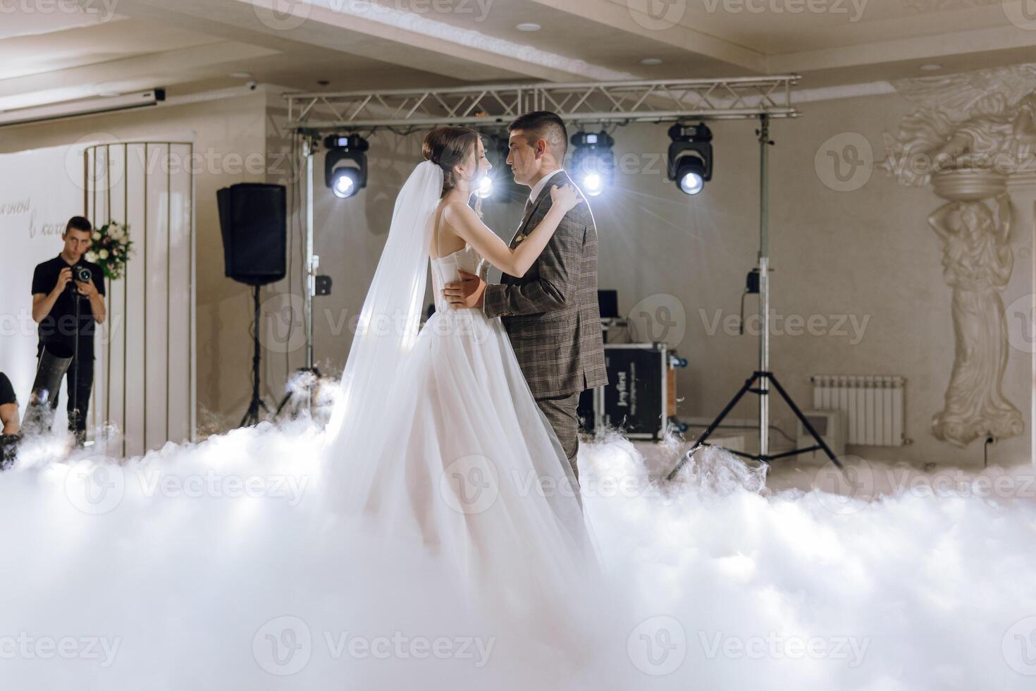 A bride and groom are dancing in the air with a cloud of smoke surrounding them photo