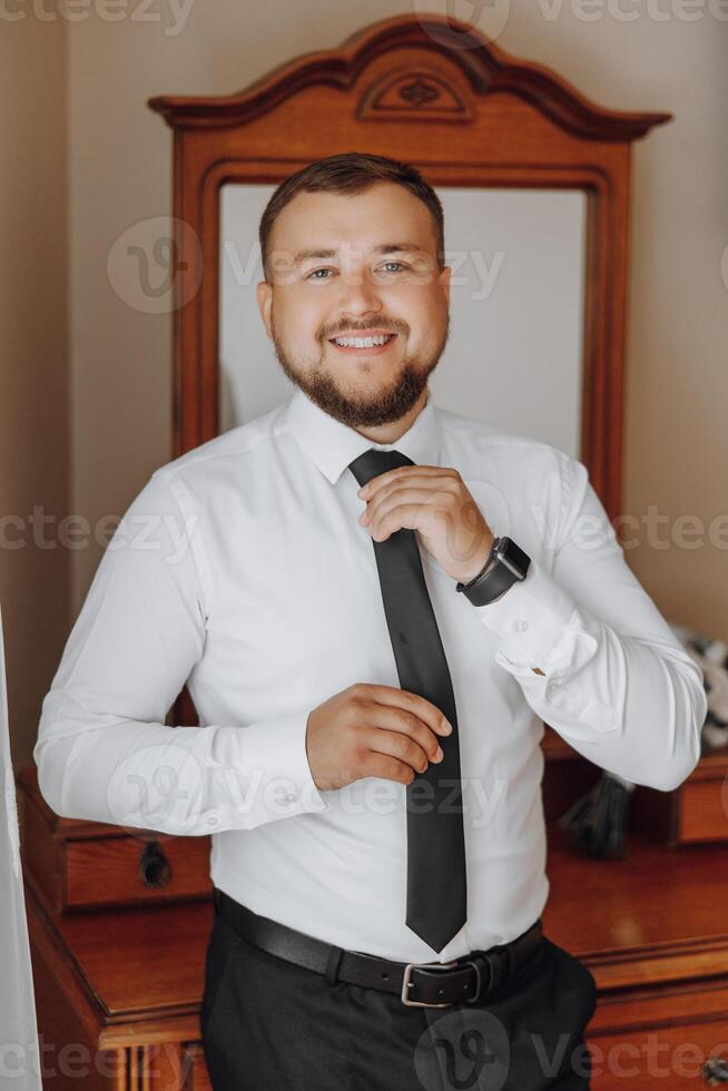 A man in a black tie is smiling and posing for a picture photo