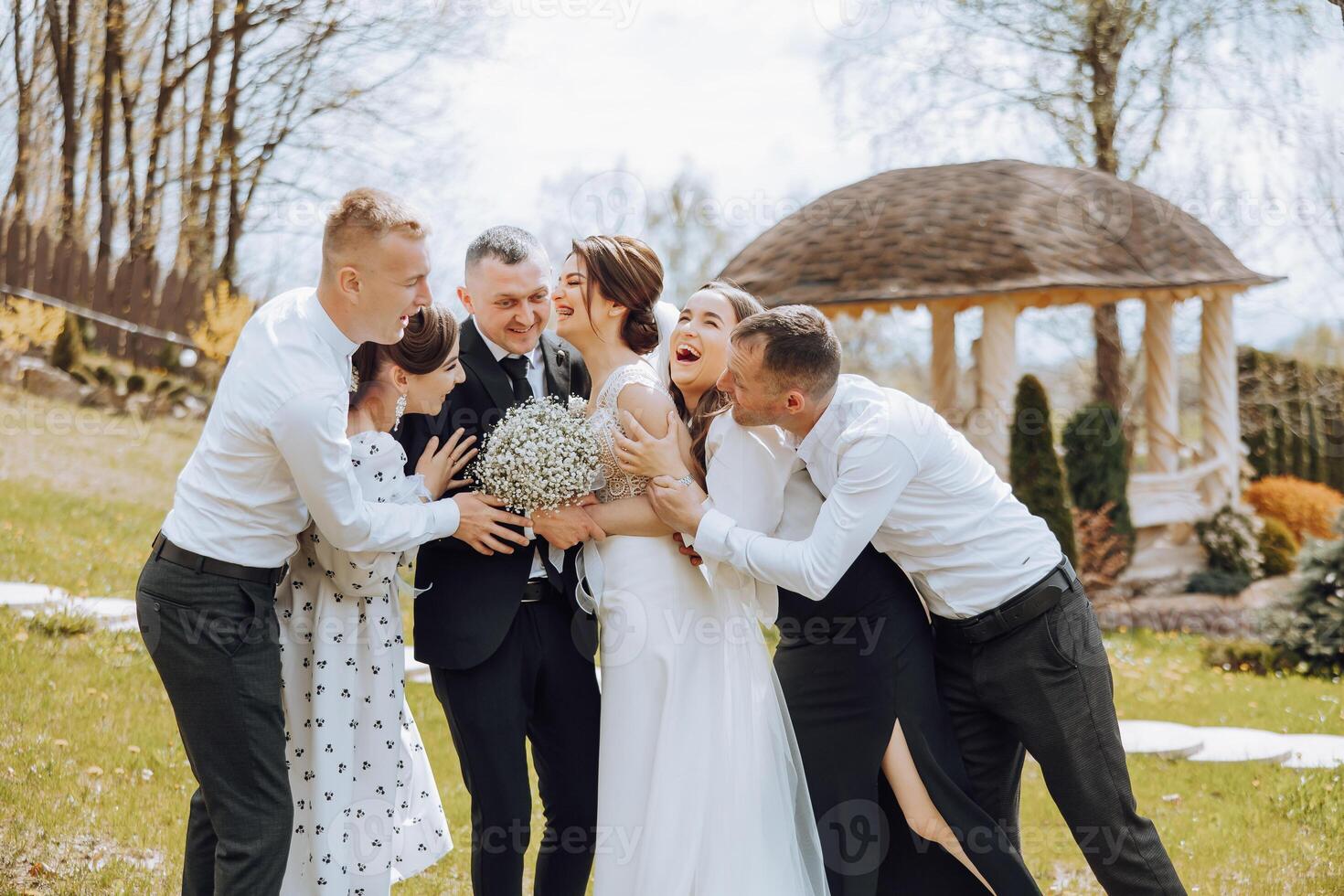 A group of people are gathered together, including a bride and groom photo