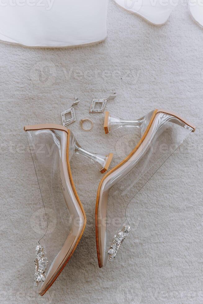 A pair of clear high heels with a diamond ring on the left photo