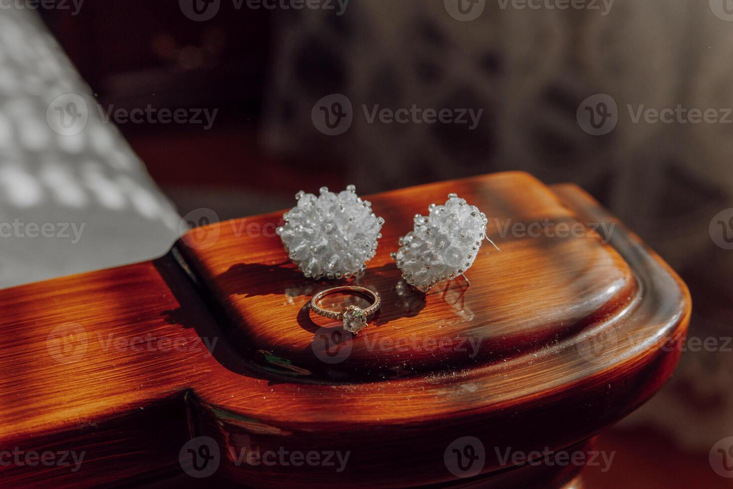 A ring and two earrings are displayed on a wooden surface photo
